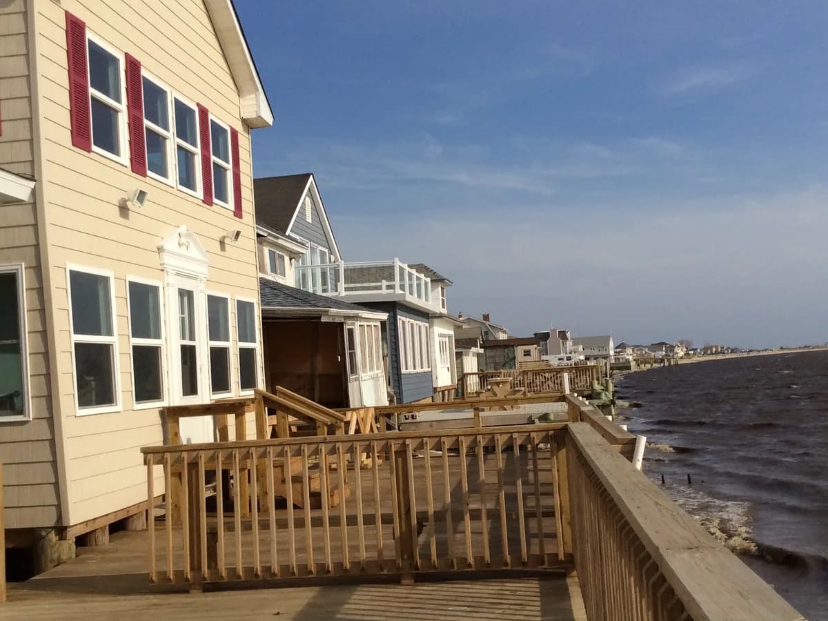 A row of bayfront cottages with wooden decks on the bulkhead